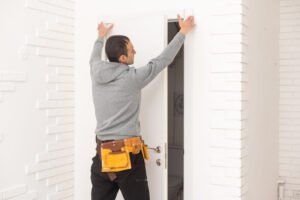 male workers carpenters installing interior door with a wooden frame at new luxury apartment.