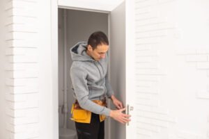male workers carpenters installing interior door with a wooden frame at new luxury apartment.